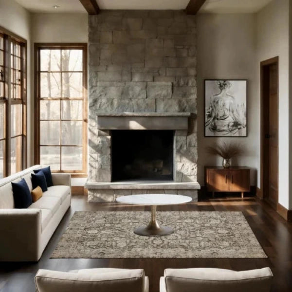 A rectangular area rug with an ornate distressed traditional pattern in muted beige, gray, and brown tones, shown flat against a white background.