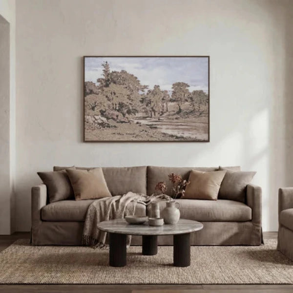 A framed landscape art print depicting a serene, muted-toned woodland scene with trees, grassy terrain, and a pale sky, shown against a plain white background.