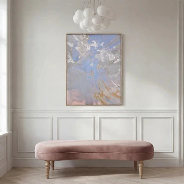 An abstract expressionist painting featuring textured impasto brushstrokes in shades of light blue, gray, white, and soft peach, enclosed in a thin metallic gold frame.